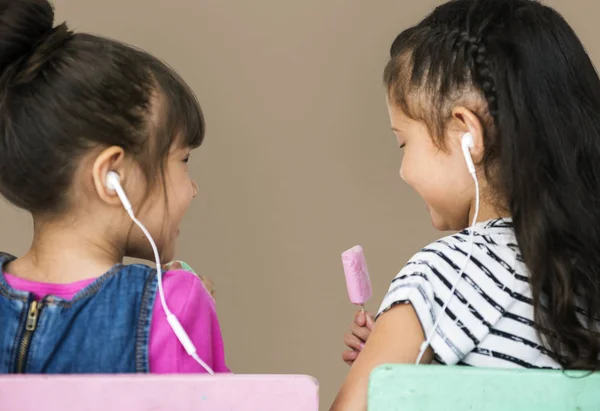 Duas meninas ouvindo música em fones de ouvido — Fotografia de Stock