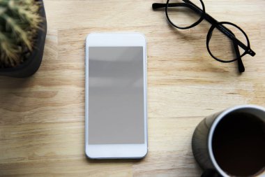 Smartphone, fincan kahve ve gözlük