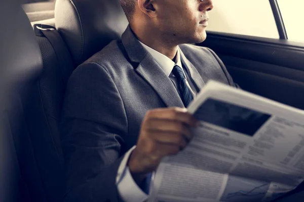 Empresário lendo jornal dentro do carro — Fotografia de Stock