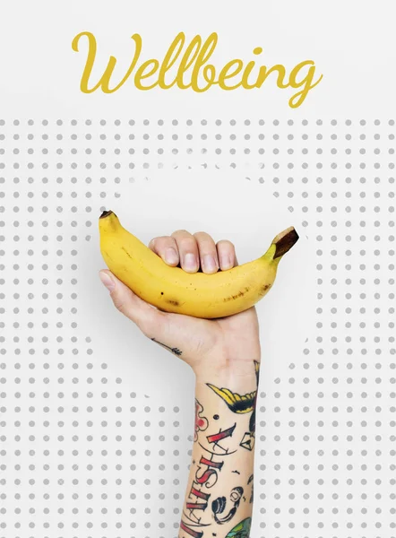 Personne tatouée tenant une banane . — Photo