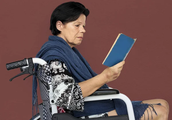 Disabled woman on wheelchair reading book — Stock Photo, Image