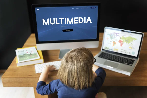 Kleines Mädchen sitzt am Arbeitstisch — Stockfoto