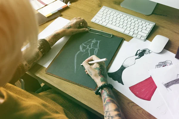 Дизайнерка жінка малює за столом — стокове фото