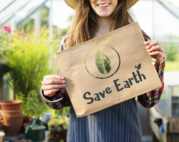 Mujer sosteniendo pancarta de papel en invernadero —  Fotos de Stock