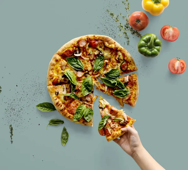 Tangan memegang sepotong pizza Italia — Stok Foto