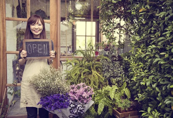 Donna che tiene aperto segno un negozio di fiori — Foto Stock