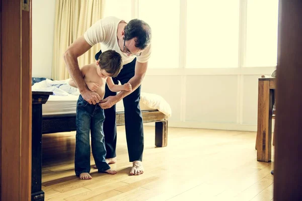 Padre ayudando a su hijo a vestirse — Foto de Stock