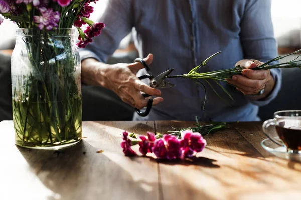 Mujer mayor cortando flores — Foto de Stock