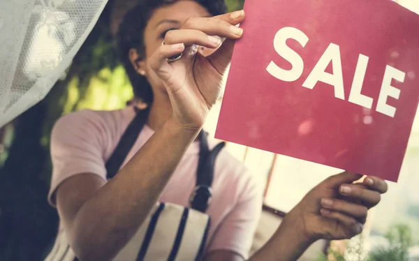 Afrikanerin in Schürze arbeitet im Geschäft — Stockfoto