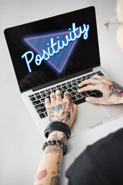 Tattooed person typing on laptop — Stock Photo, Image