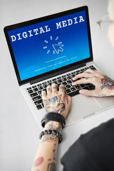 Getatoeëerde persoon typen op laptop — Stockfoto