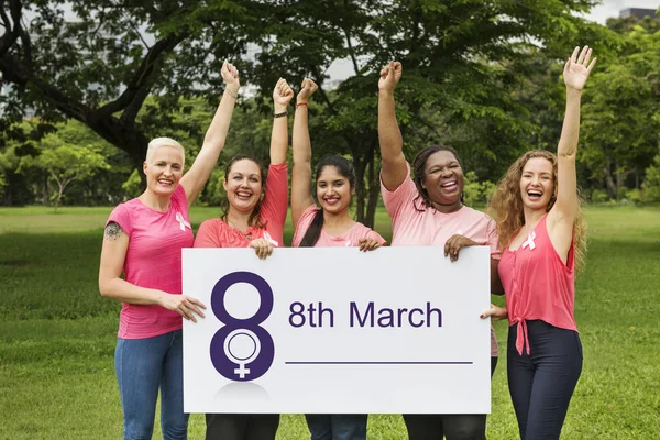 Cinco mujeres sonrientes sosteniendo pancarta — Foto de Stock