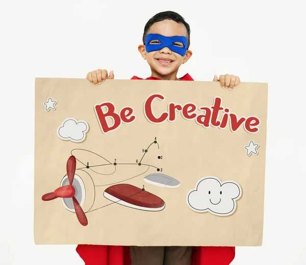 Хлопчик в костюмі супергерой тримає плакат — стокове фото