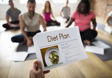 Yoga sınıfındaki katta oturan insanlar