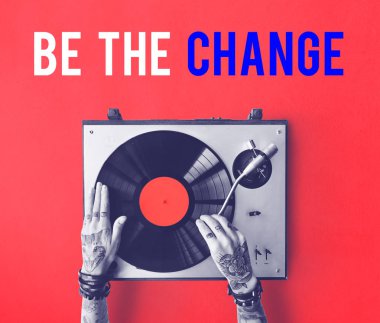 Vinil player ile dövmeli kişi.