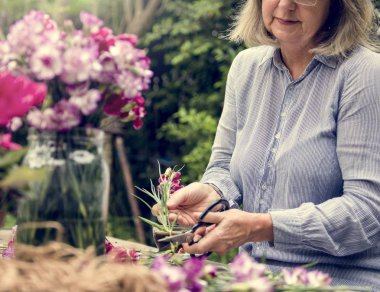 Olgun Bayan çiçek düzenliyor
