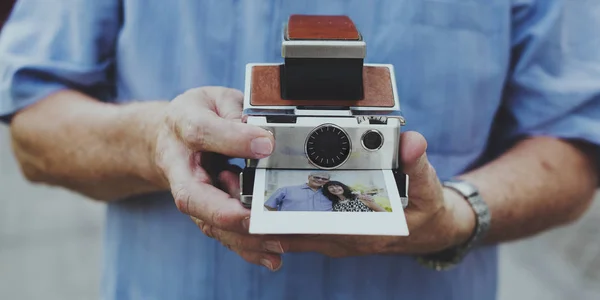 Un mec tenant une caméra instantanée rétro — Photo