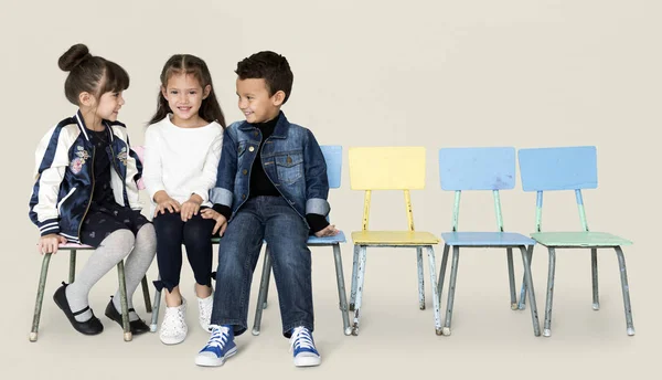Crianças sentadas em cadeiras e conversando — Fotografia de Stock