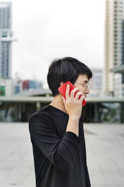 Asyalı çocuk Smartphone açık havada üzerinde konuşuyor