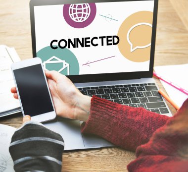 dizüstü bilgisayar önünde Smartphone kullanan kişiler