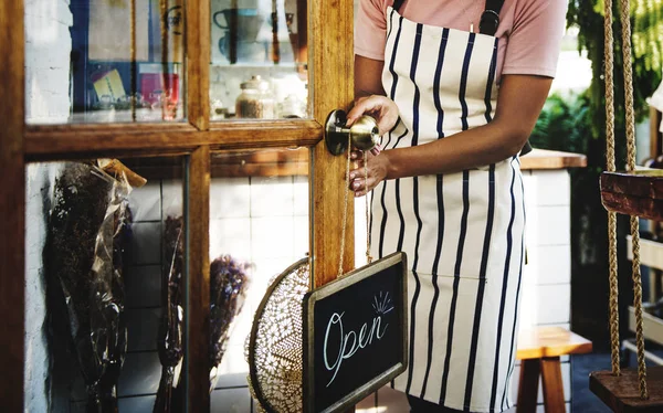 African woman in apron working in shop — Stock Photo, Image