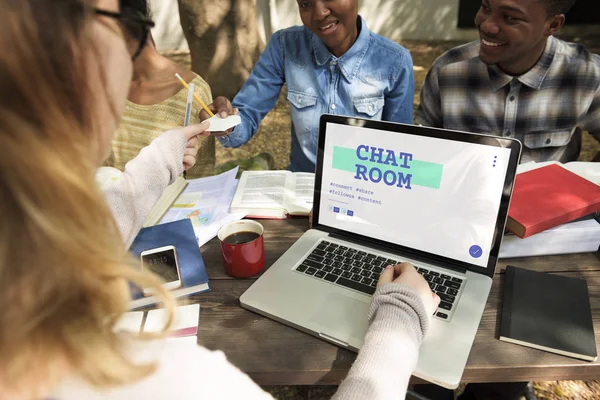 Studenti seduti a tavola con libri e laptop — Foto Stock