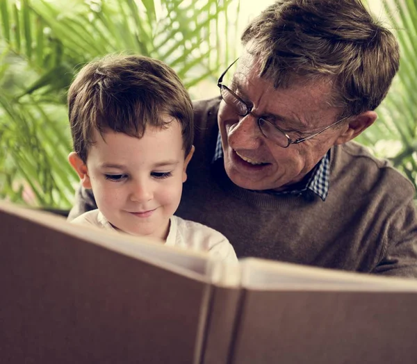 Дід і онук читають книгу — стокове фото