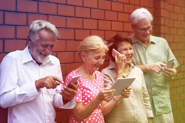 Anziani che utilizzano dispositivi digitali — Foto Stock