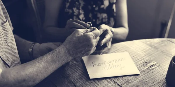Старший мужчина дарит жене кольцо — стоковое фото