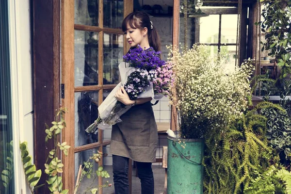 Florista segurando buquês na loja de flores — Fotografia de Stock