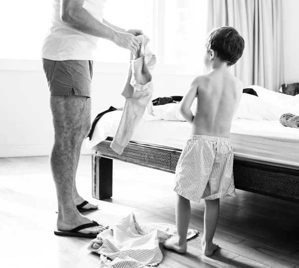 Отец помогает сыну одеться — стоковое фото