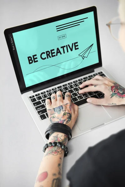 Tattooed person typing on laptop — Stock Photo, Image