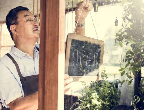 Ο άνθρωπος που κρέμονται ξύλινη πινακίδα "ανοιχτά" στο παράθυρο — Φωτογραφία Αρχείου