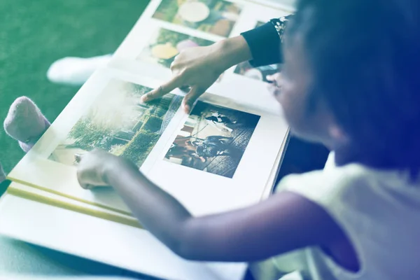 Girl looking at photo album — Stock Photo, Image