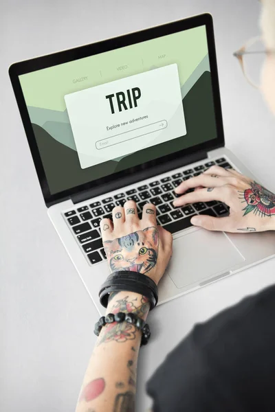 Getatoeëerde persoon typen op laptop. — Stockfoto