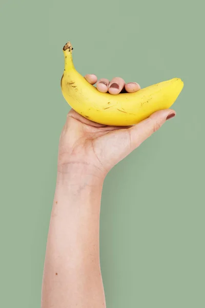 Человеческая рука, держащая банан — стоковое фото