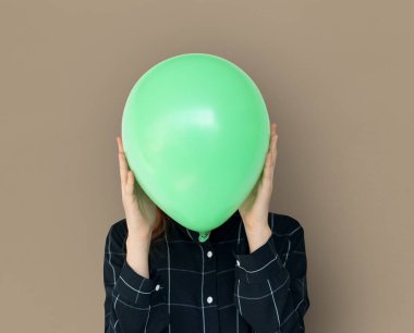 Yeşil balon ile yüz kapsayan kadın