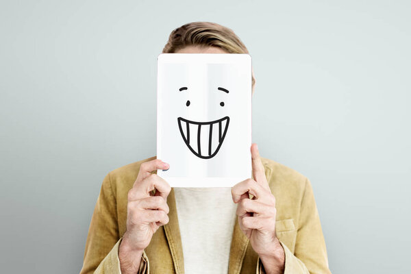 человек держит цифровой планшет закрывая лицо
 