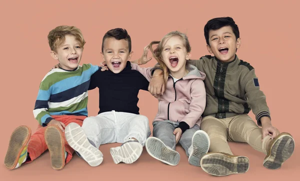 Niños sonrientes sentados en el suelo T —  Fotos de Stock