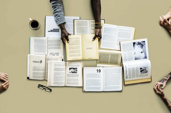 Mãos à mesa com muitos livros — Fotografia de Stock