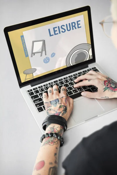 Getatoeëerde persoon typen op laptop. — Stockfoto