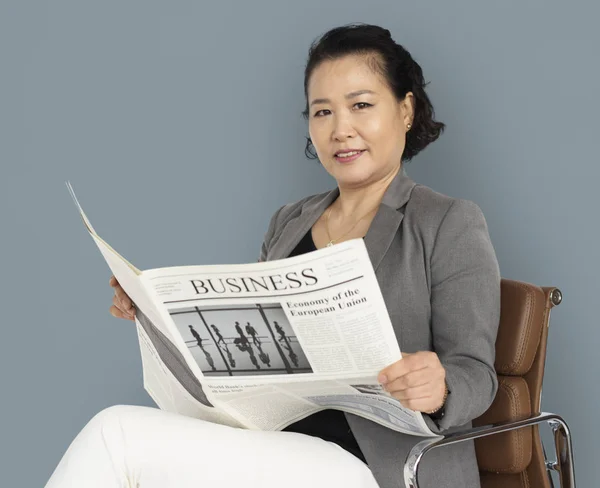 Азиатская деловая женщина с газетой — стоковое фото