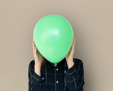 Yeşil balon ile yüz kapsayan kadın
