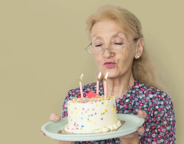 Sênior mulher acendendo velas — Fotografia de Stock