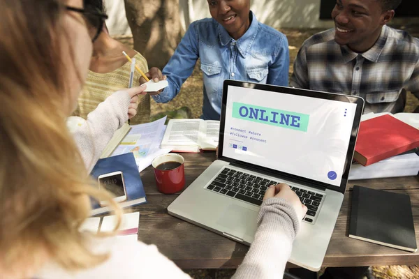 Studenti seduti a tavola con libri e laptop — Foto Stock