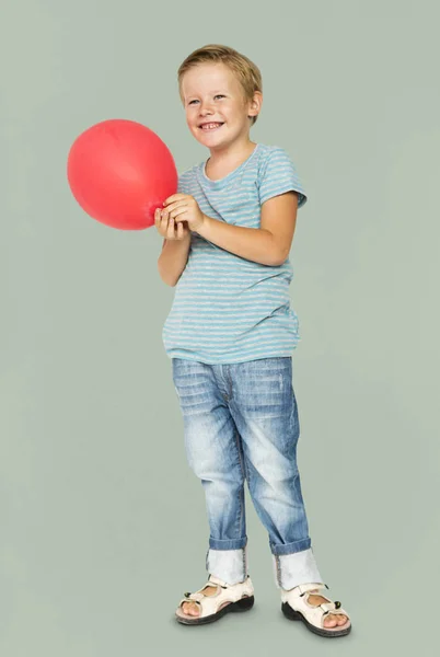Poika punaisella ilmapallolla — kuvapankkivalokuva