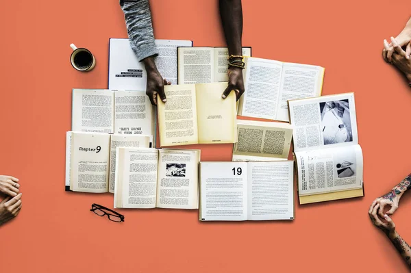 Mãos à mesa com muitos livros — Fotografia de Stock