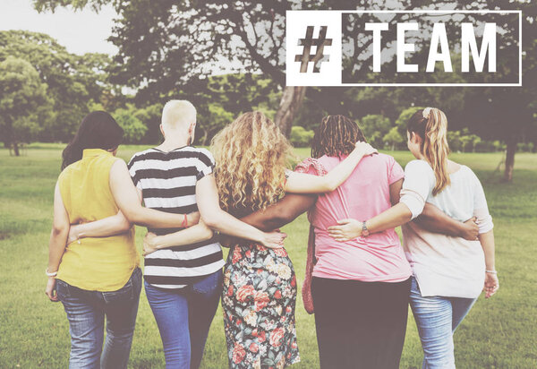 five women embracing in front of park