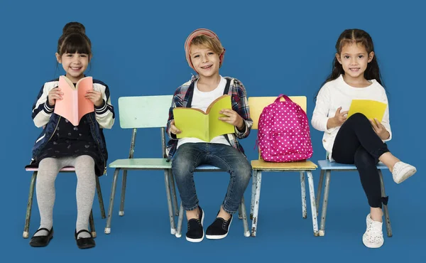 Schoolgaande kinderen zitten op stoelen — Stockfoto