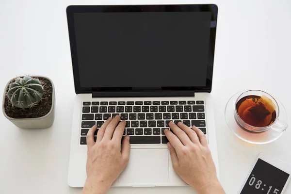 Mãos humanas usando laptop à mesa — Fotografia de Stock